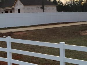8 ft tall privacy fence in back with white ranch rail in front, both vinyl